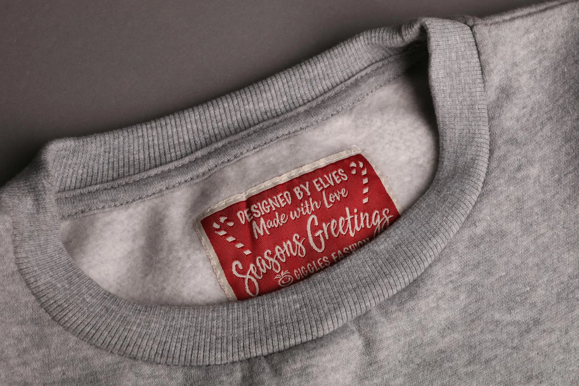 Eingewebtes Pflegeetikett mit Faserzusammensetzung und Waschsymbolen am Kragen eines T-Shirts