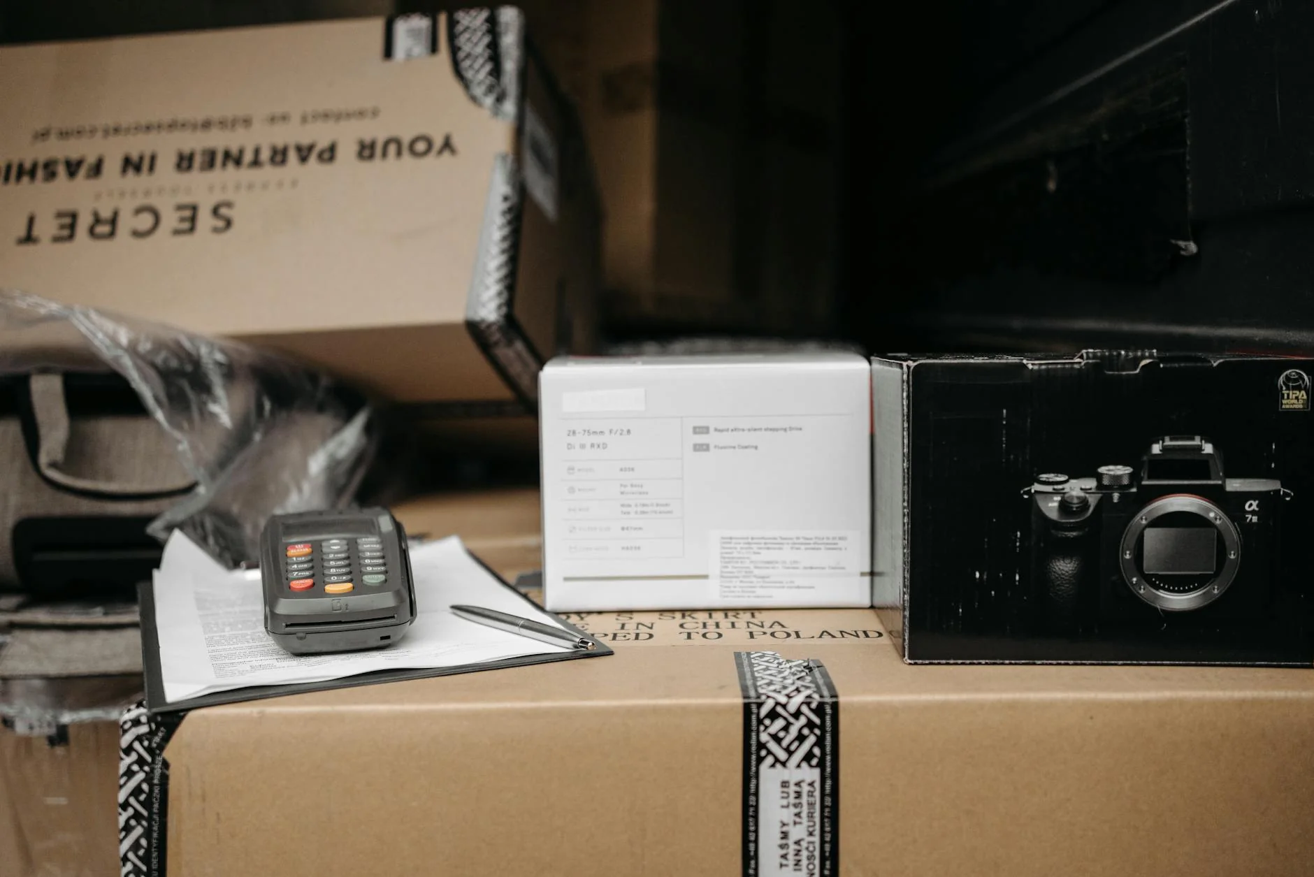 Vielfältige Konsumgüter in Versandkartons auf einem Packtisch im Lager eines Online-Händlers